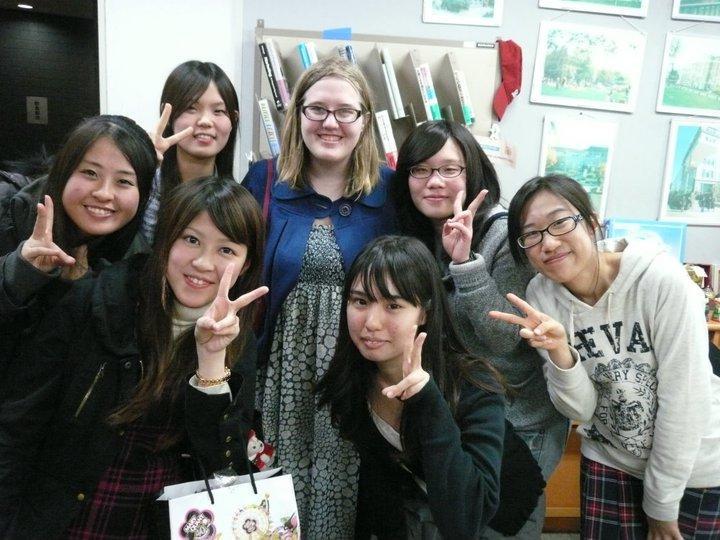 A group of people posing together, some making peace signs.