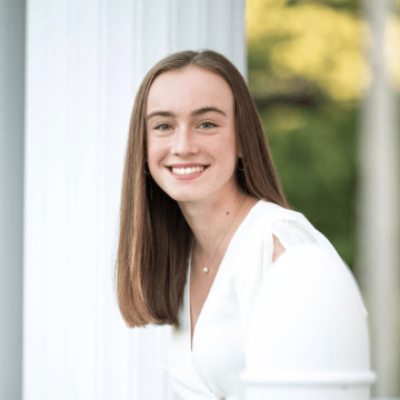 A person in a white outfit smiling.