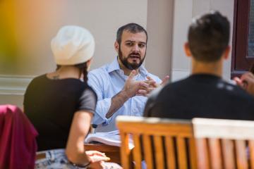 A faculty member discussing academic integrity with two students.