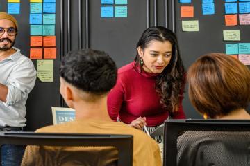 People planning a course with sticky notes on the wall.