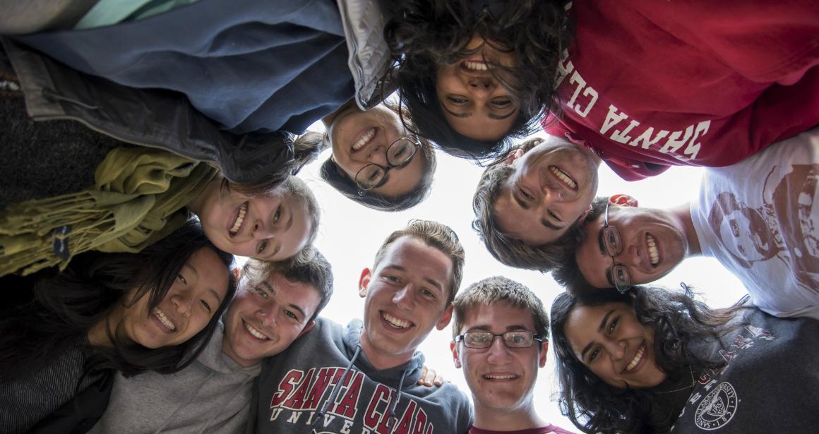 Students in a circle looking down, smiling; 'Class of 2019 Group Photo'. image link to story