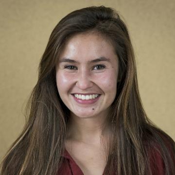 Smiling person against a beige background, titled 