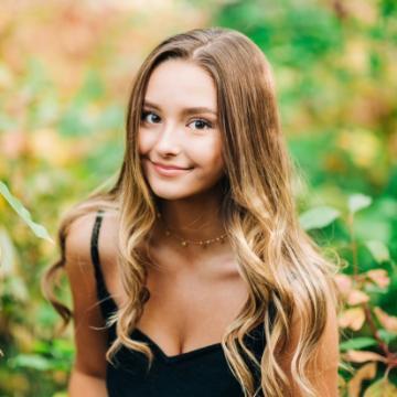 Young woman with a pleasant smile in a garden.