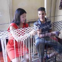 Two people talking near a metal railing indoors.