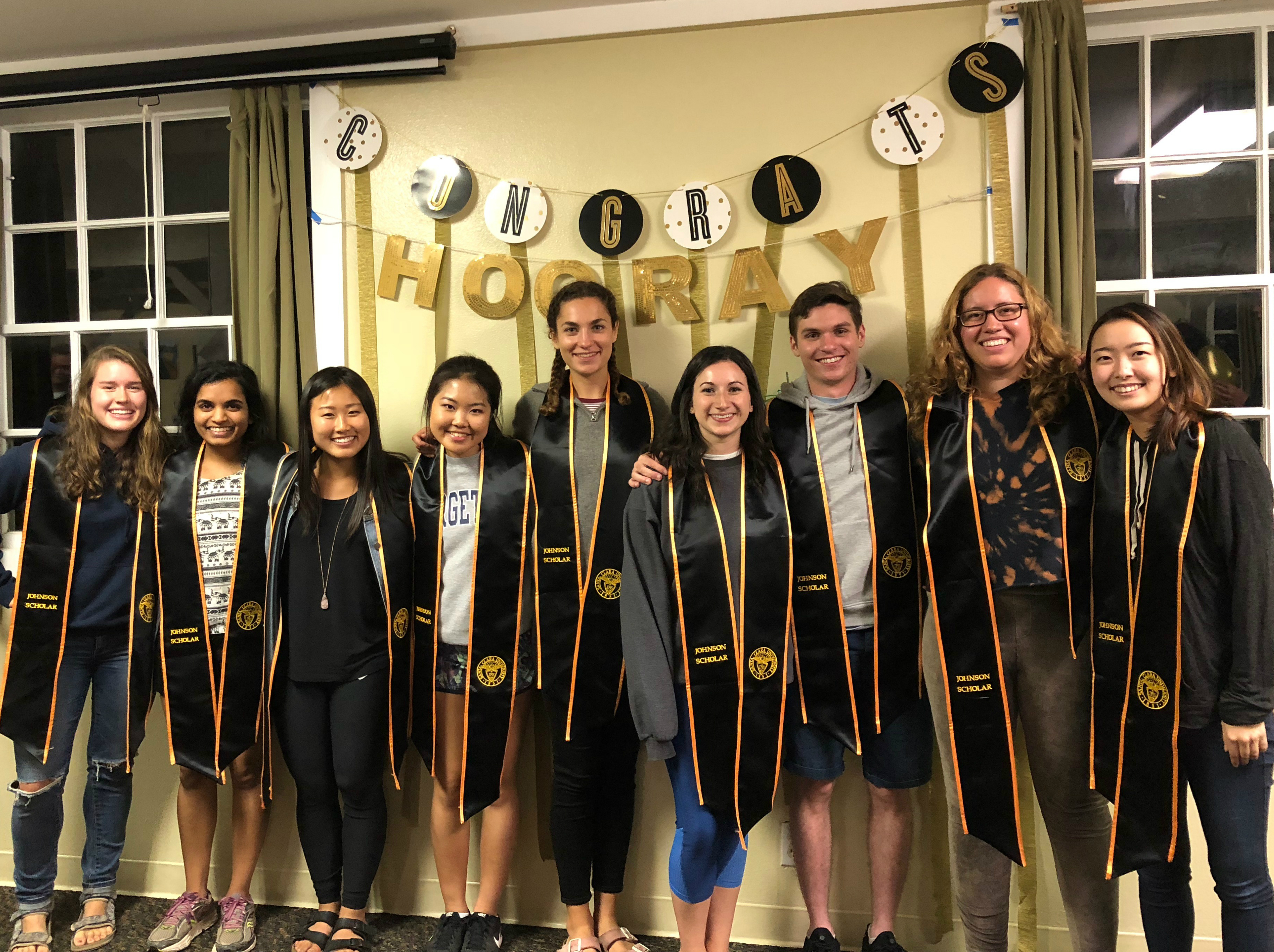 A group of graduates in caps and gowns celebrating. image link to story