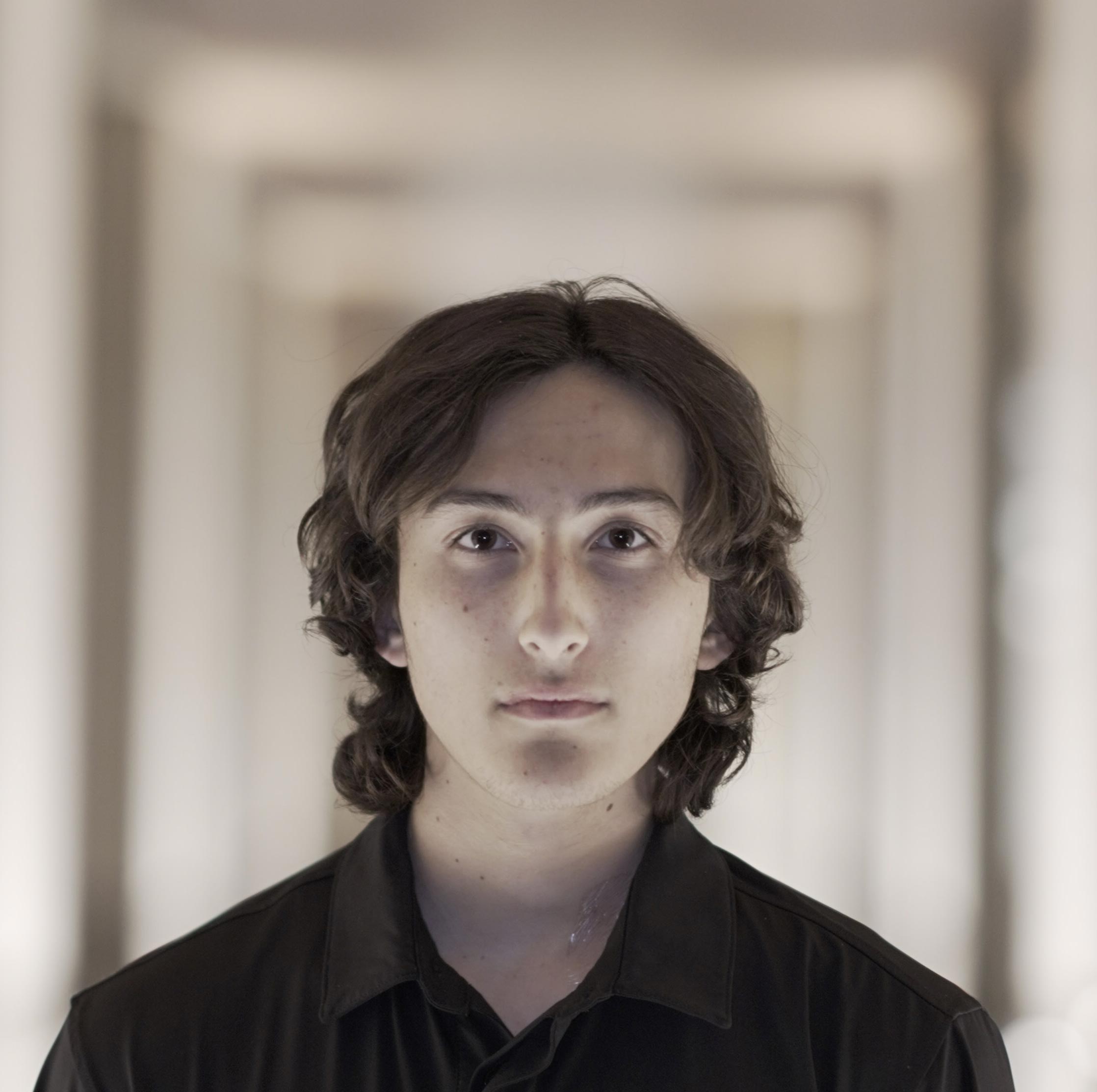 A person standing in a corridor, titled 'Bill Caramanica'.