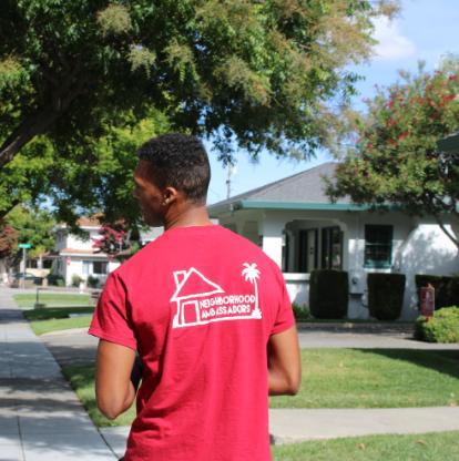 Backside view of Neighborhood Ambassador walking through the neighborhood