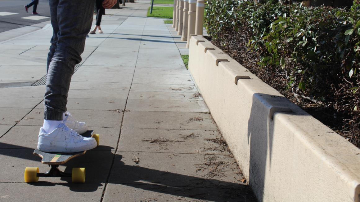 A person riding a skateboard on campus