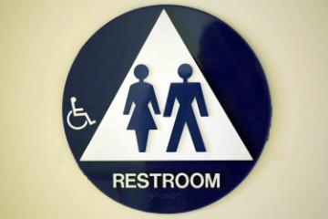 Restroom sign with symbols for men, women, and accessibility.