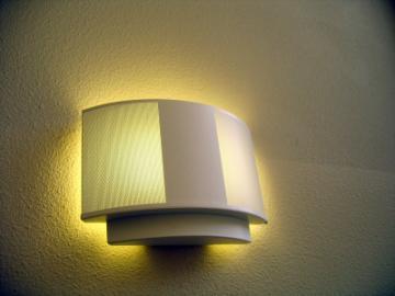 Wall-mounted light fixture casting a warm glow on a wall.