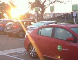 Parking lot with Zipcar vehicles at sunset.