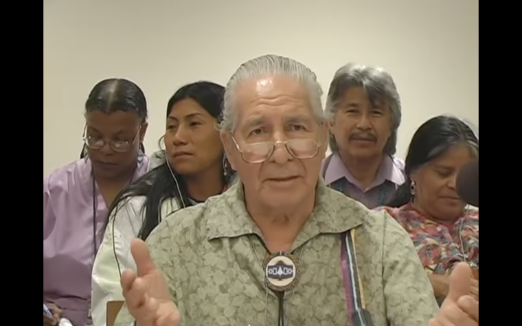 Chief Oren Lyons speaks with other forum attendees listening behind