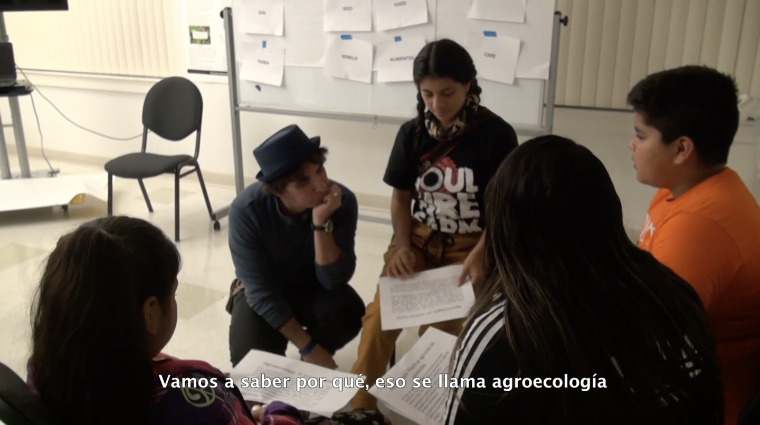 A group of young adults sits in a circle discussion in a workshop