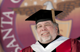 Man in graduation attire at podium with university background. image link to story