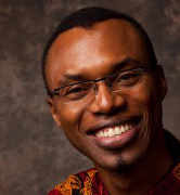 A person smiling while wearing glasses and a patterned shirt. image link to story
