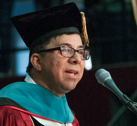 A person giving a speech in academic regalia. image link to story