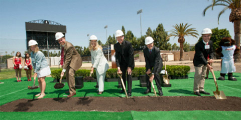 People with shovels breaking ground for a new soccer center.