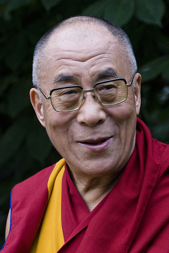 The Dalai Lama wearing glasses and traditional robes, smiling. image link to story