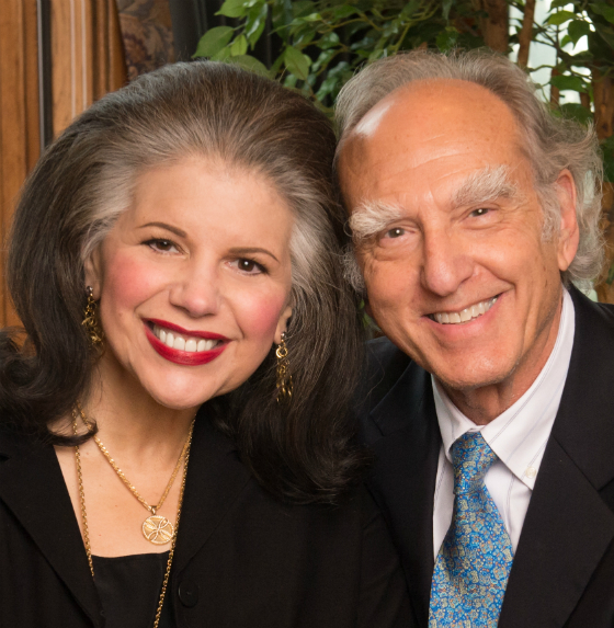 A smiling man and woman posing together indoors.