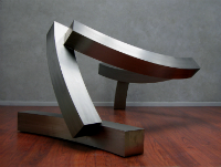 Abstract metal sculpture on a wooden floor with gray backdrop. image link to story