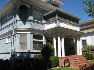 A two-story house with a porch and large windows.