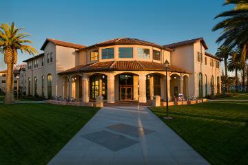 Graham Residence Hall building with a palm tree on each side.