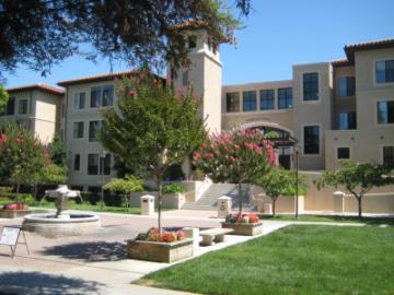 Sobrato Hall building with grassy courtyard and walkway.