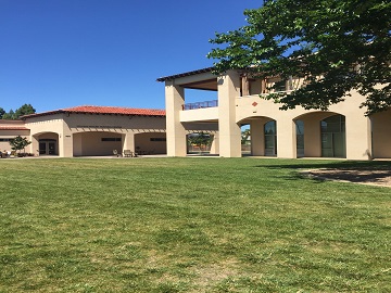 Two-story building with a grassy lawn in sunny weather.