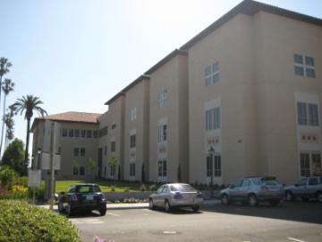 Lucas Hall South building exterior with parked vehicles and surrounding greenery.