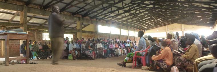 A large, industrial workspace with people attending an event or workshop.