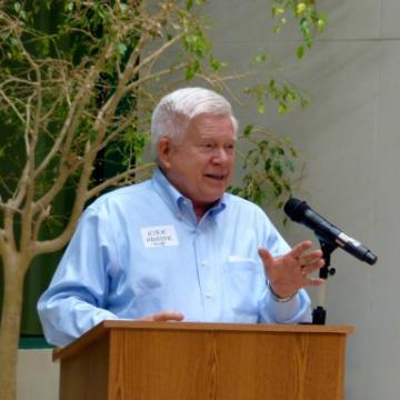 A person speaking at a podium with a microphone.