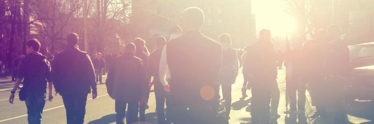 A group of people walking towards sunlight.