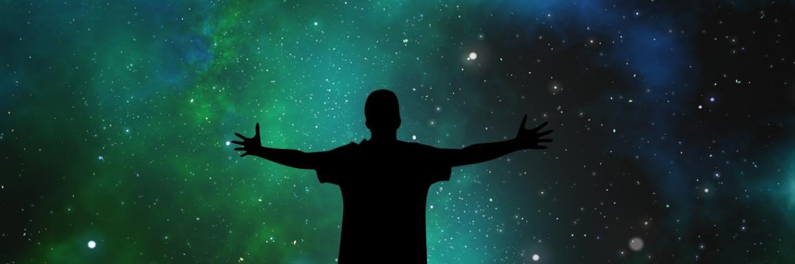 Silhouette of a person with arms outstretched against a starry night sky.