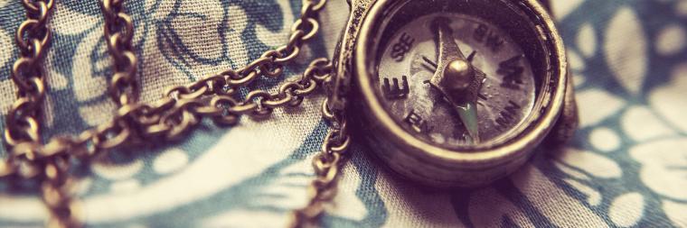 Vintage pocket watches and chains on a patterned surface.