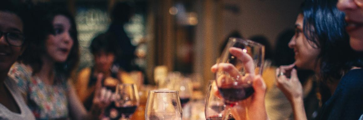 A diverse group of friends talking enthusiastically over glasses of wine