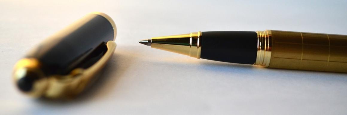 A gold and black pen with its cap removed.