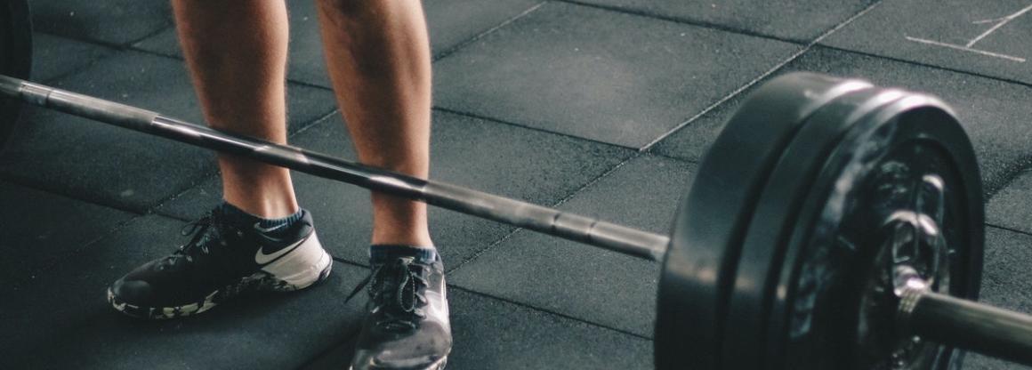 Man standing in front of barbells.