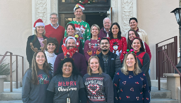 Group of people wearing holiday sweaters. 