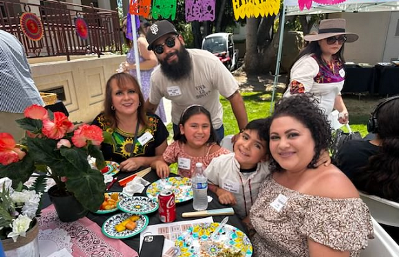 Family sitting a table smiling.