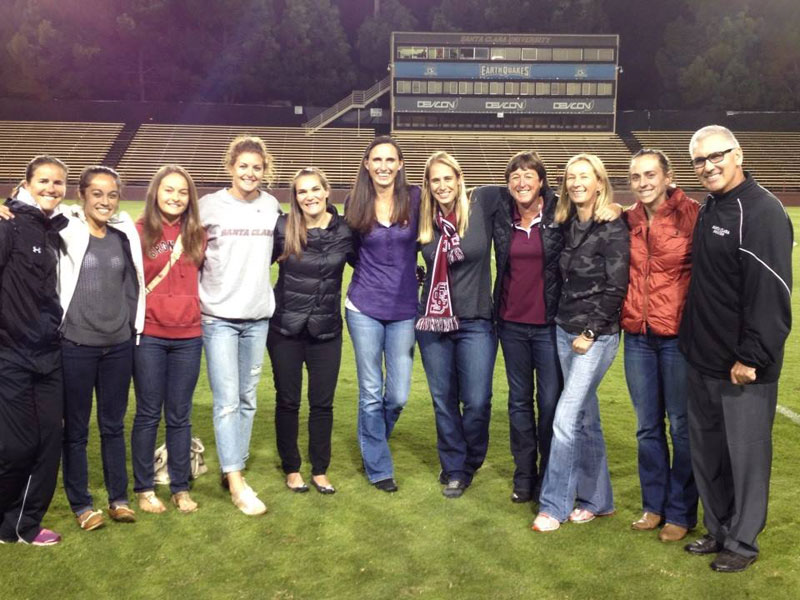 Group of people posing on soccer field during Alumni Night at Women's Soccer vs USD.
