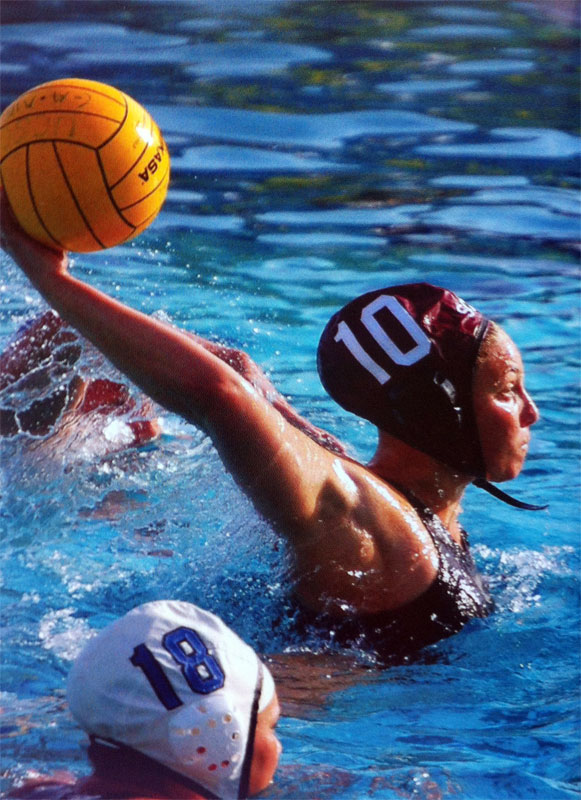 Water polo player preparing to throw, wearing number 10 cap, in a pool.