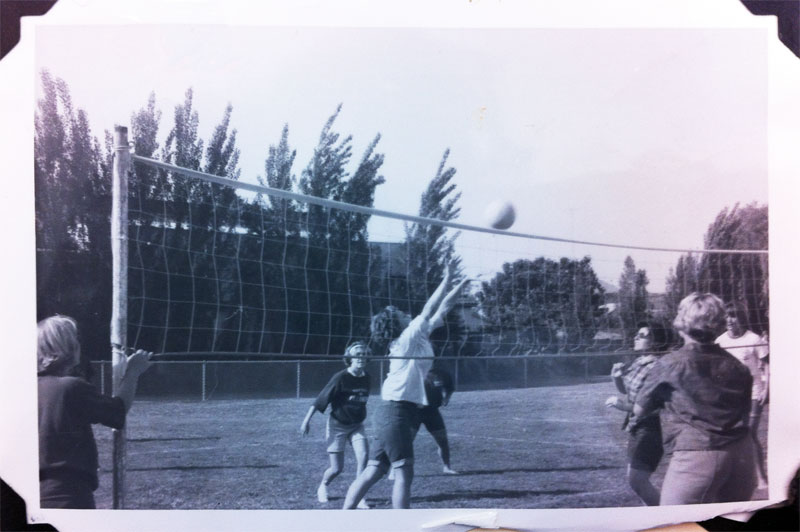 Black and white photo of a volleyball game being played outdoors in 1964.