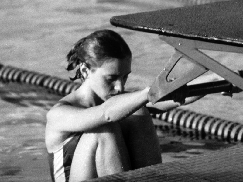 A person preparing to swim by the poolside.