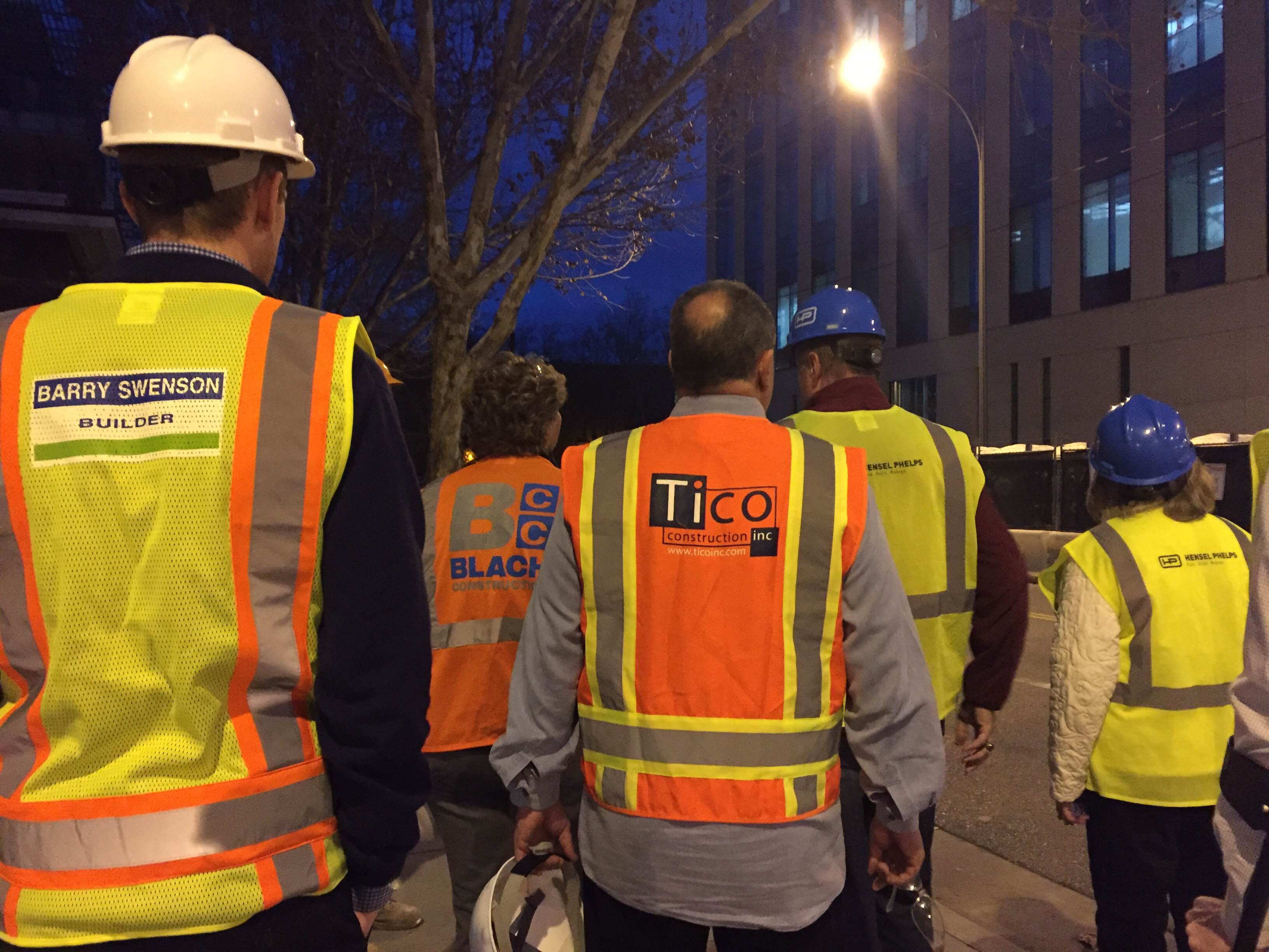 Construction workers in safety gear at night with 