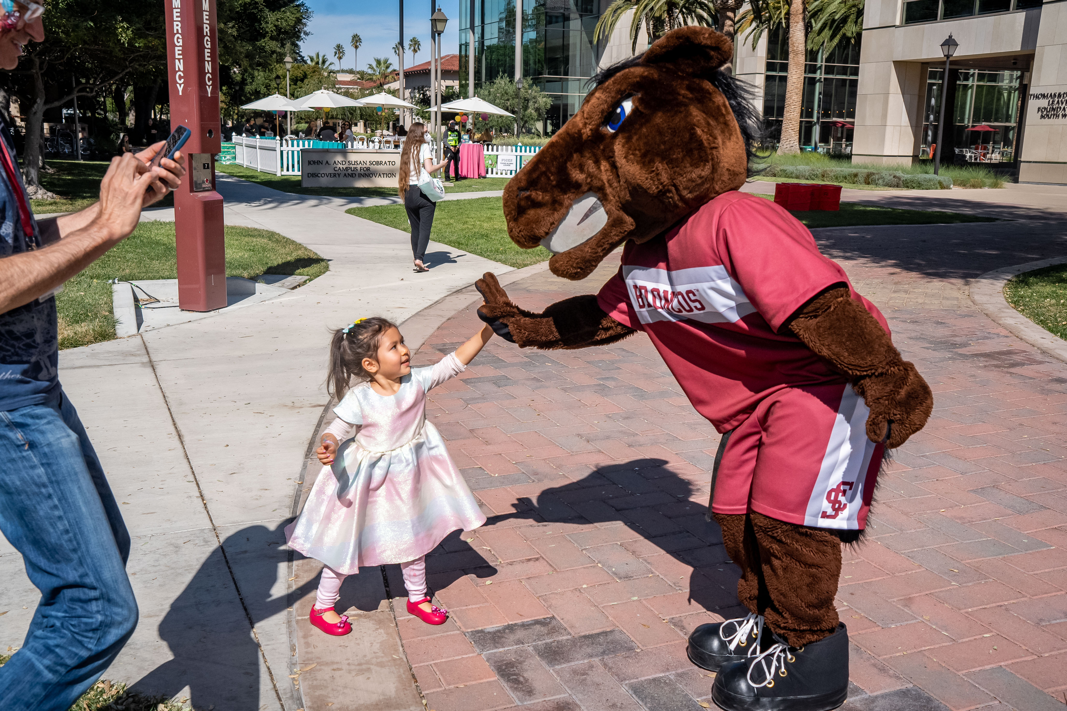 Young child high fiving Bucky Bronco