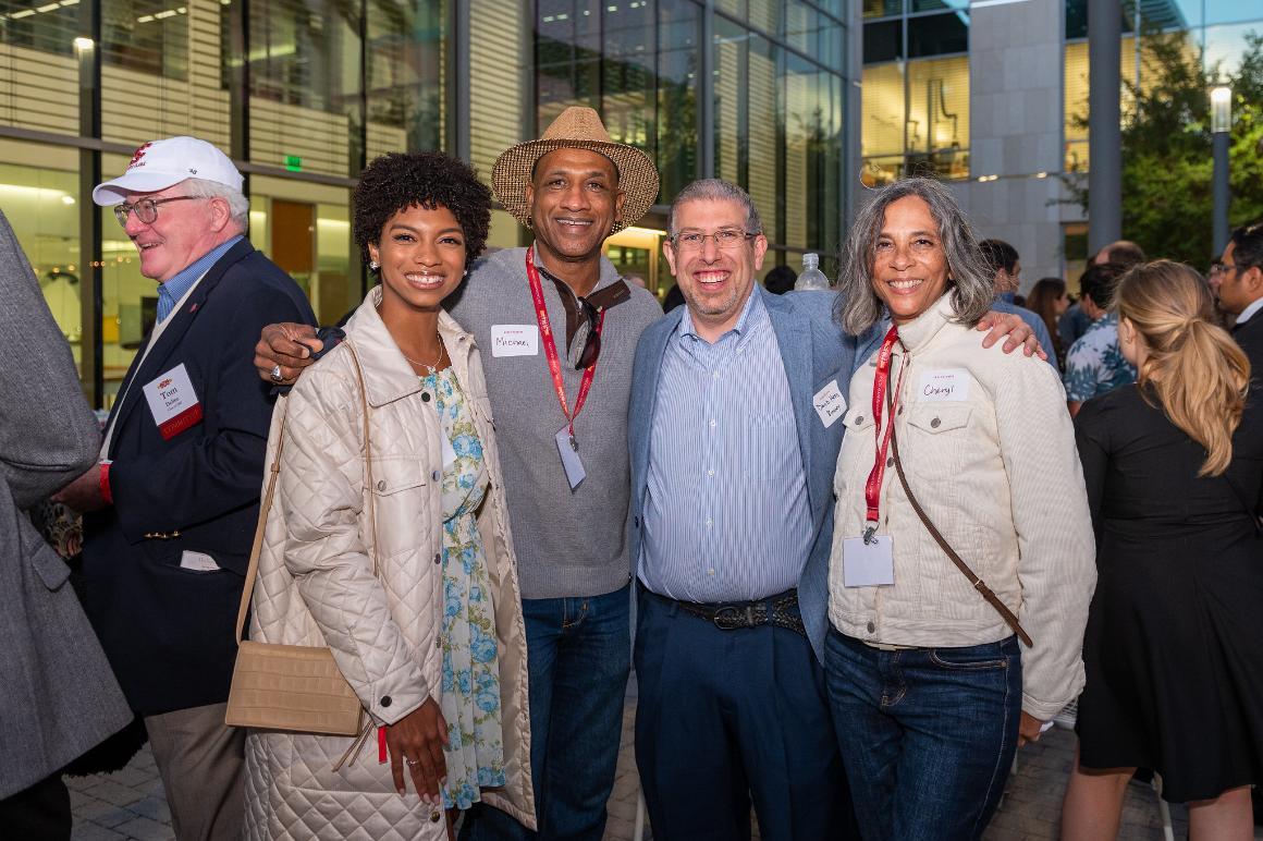 A group of people smiling at an arts and sciences reception.