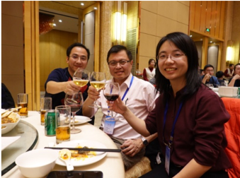 Three people toasting drinks at a restaurant table.