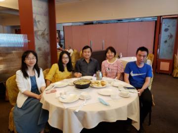 Five people sitting at a round table in a restaurant.