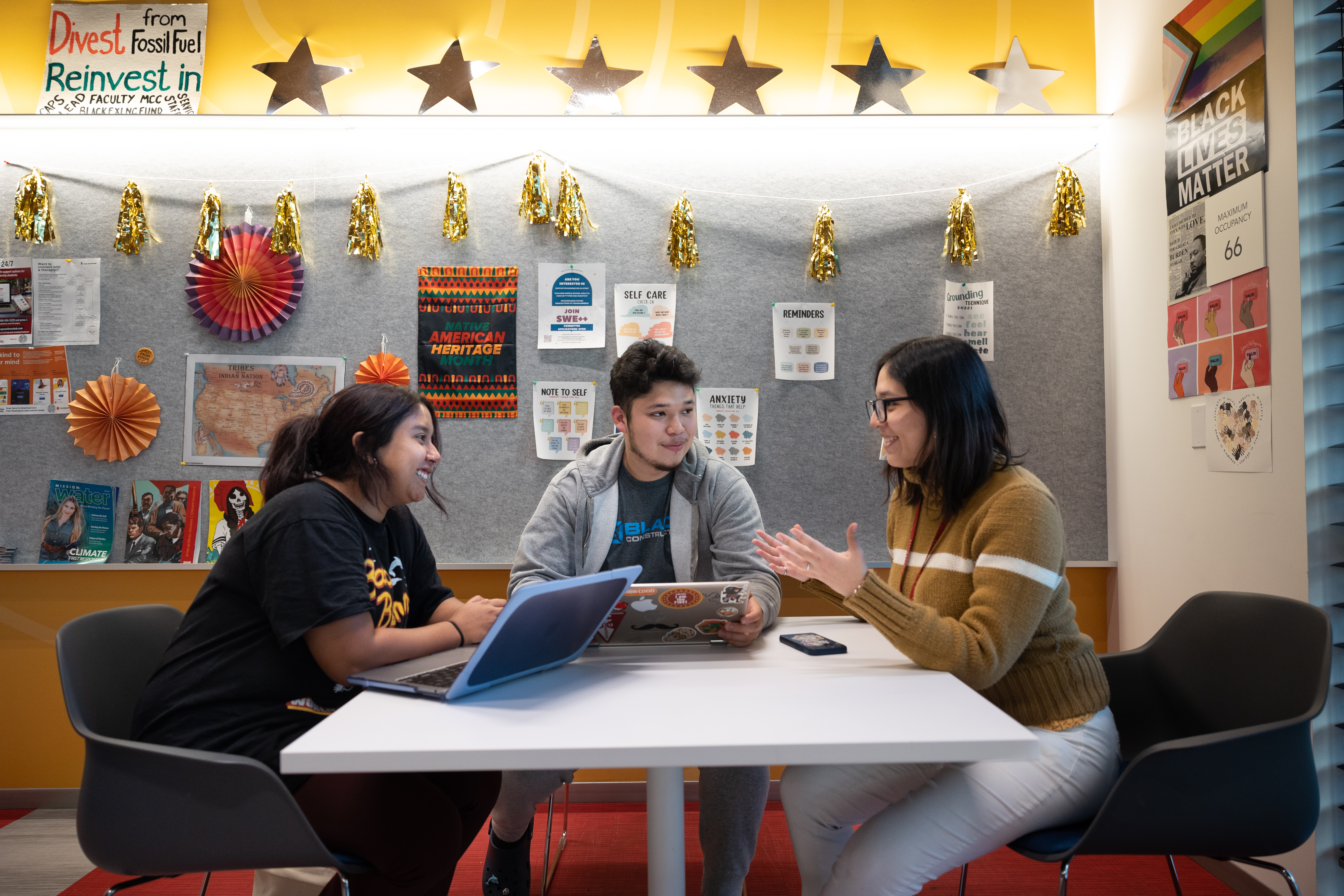 Three students sitting together collaborating.