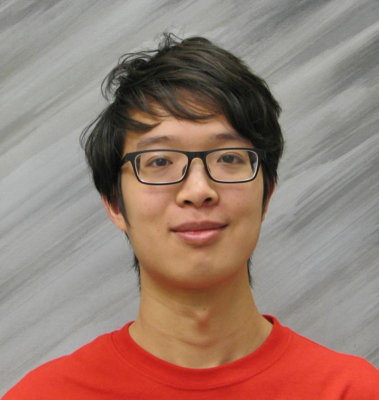 A person wearing glasses and a red shirt with a gray background.